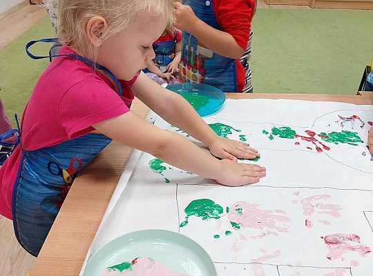 Dziewczynka odbija dłonie na papierze