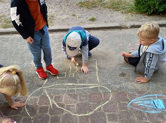 Dzieci rysują kredą na chodniku