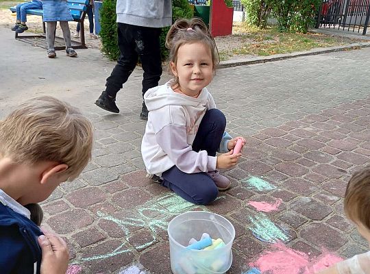 Dzieci rysują kredą na chodniku