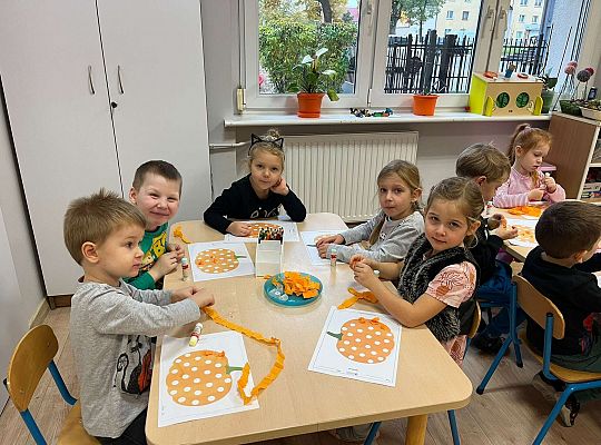 Dzieci wyklejają dynię