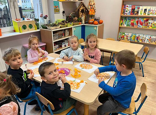 Dzieci wyklejają dynię