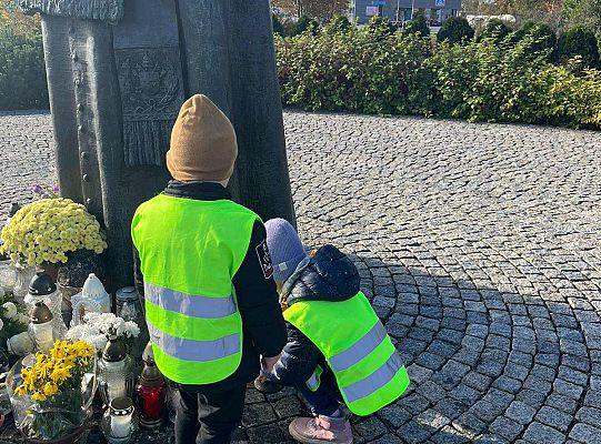 Dzieci stawiają znicz