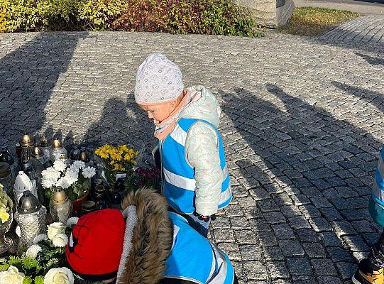 Dzieci stawiają znicz