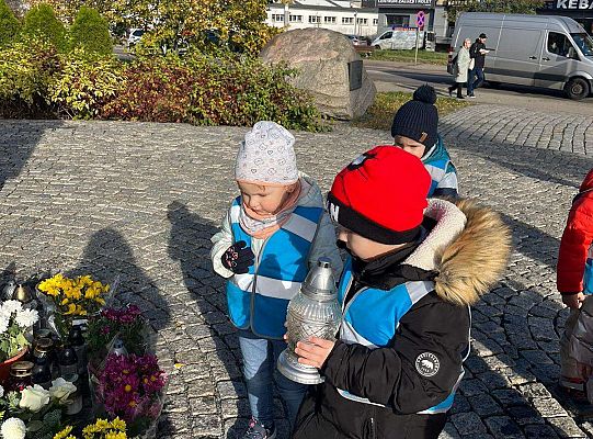 Dzieci stawiają znicz