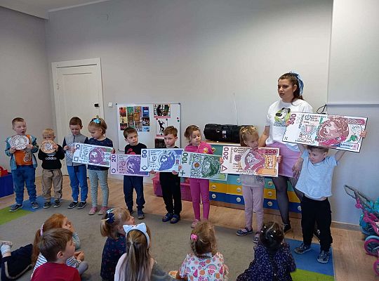 Dzieci z planszami banknotów i monet