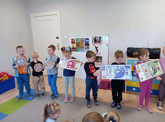 Dzieci z planszami banknotów i monet