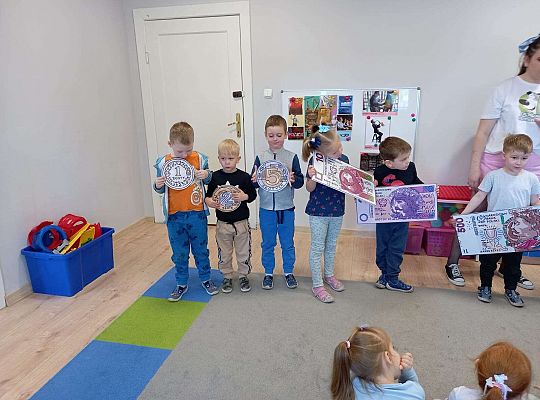 Dzieci z planszami banknotów i monet