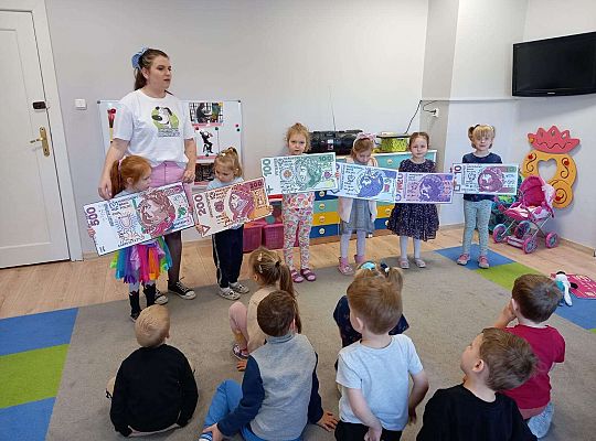 Dzieci z planszami banknotów i monet