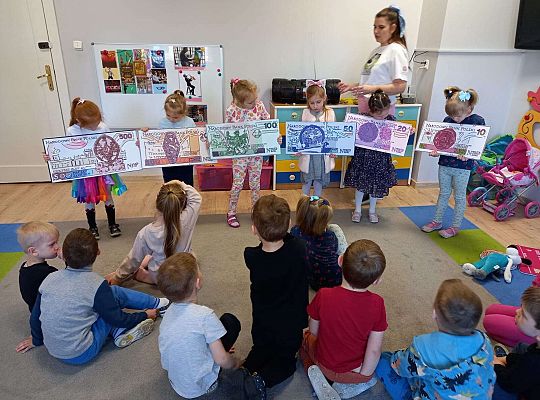 Dzieci z planszami banknotów i monet